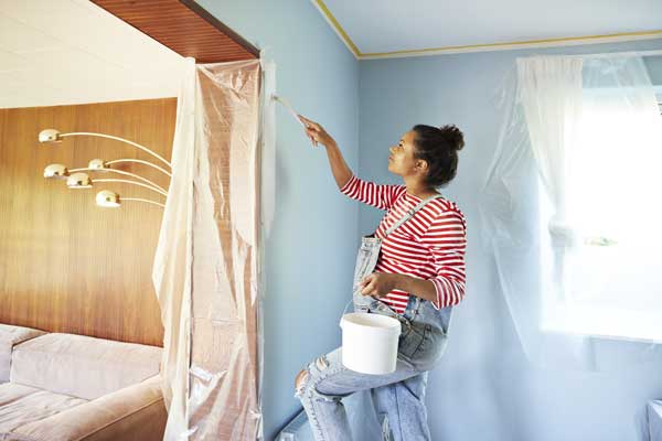 Kvinna som målar en vägg